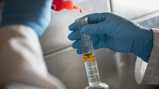 化学实验图像，将黄色液体加入透明液体的小瓶中. 